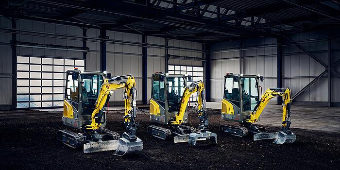 three mini excavators in a row