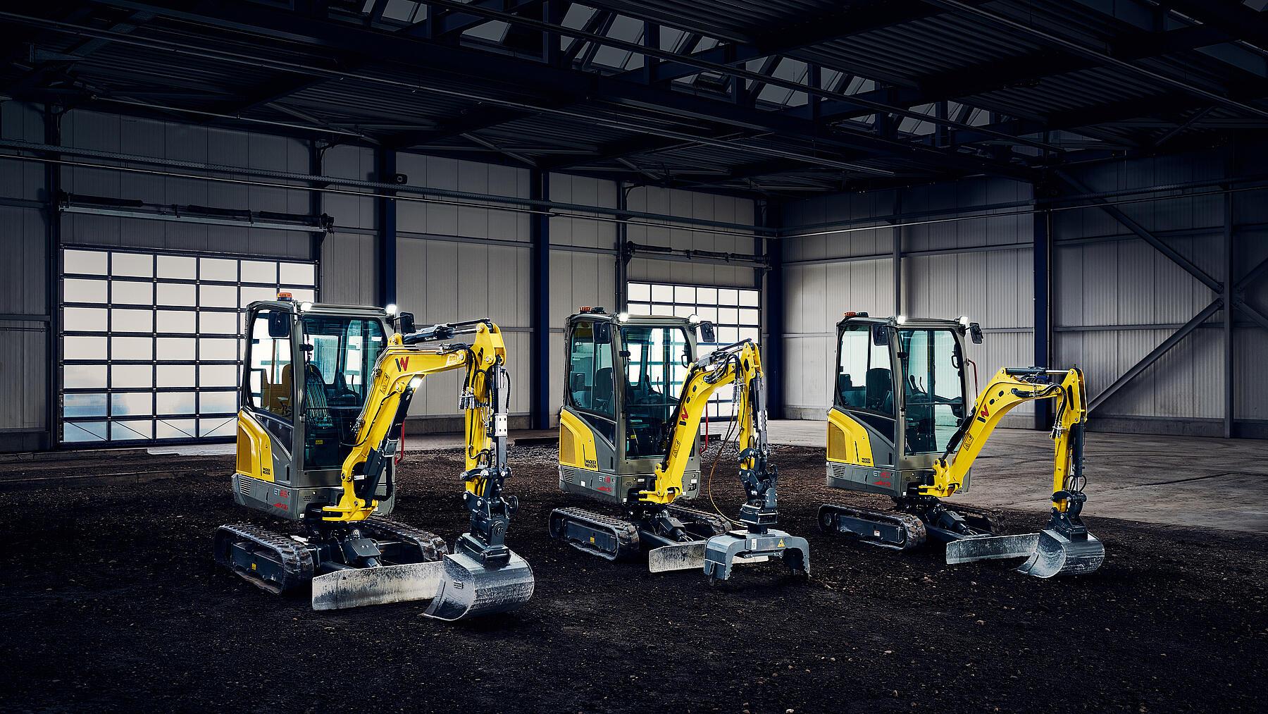 three mini excavators in a row