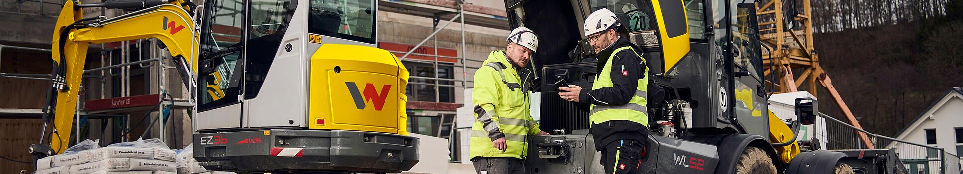 two customers standing in front of wacker neuson machines
