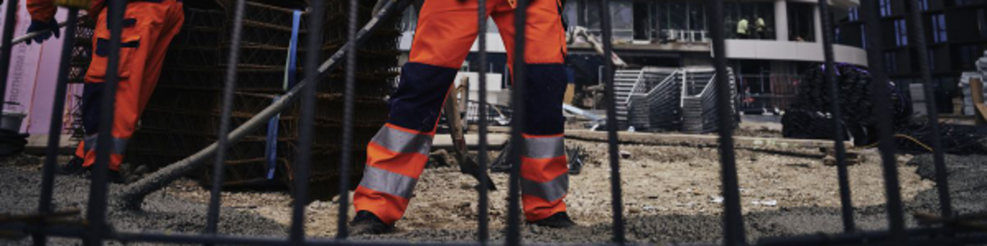 Bauarbeiter auf einer Baustelle, der mit einem Wacker Neuson Innenrüttler Beton verdichtet.