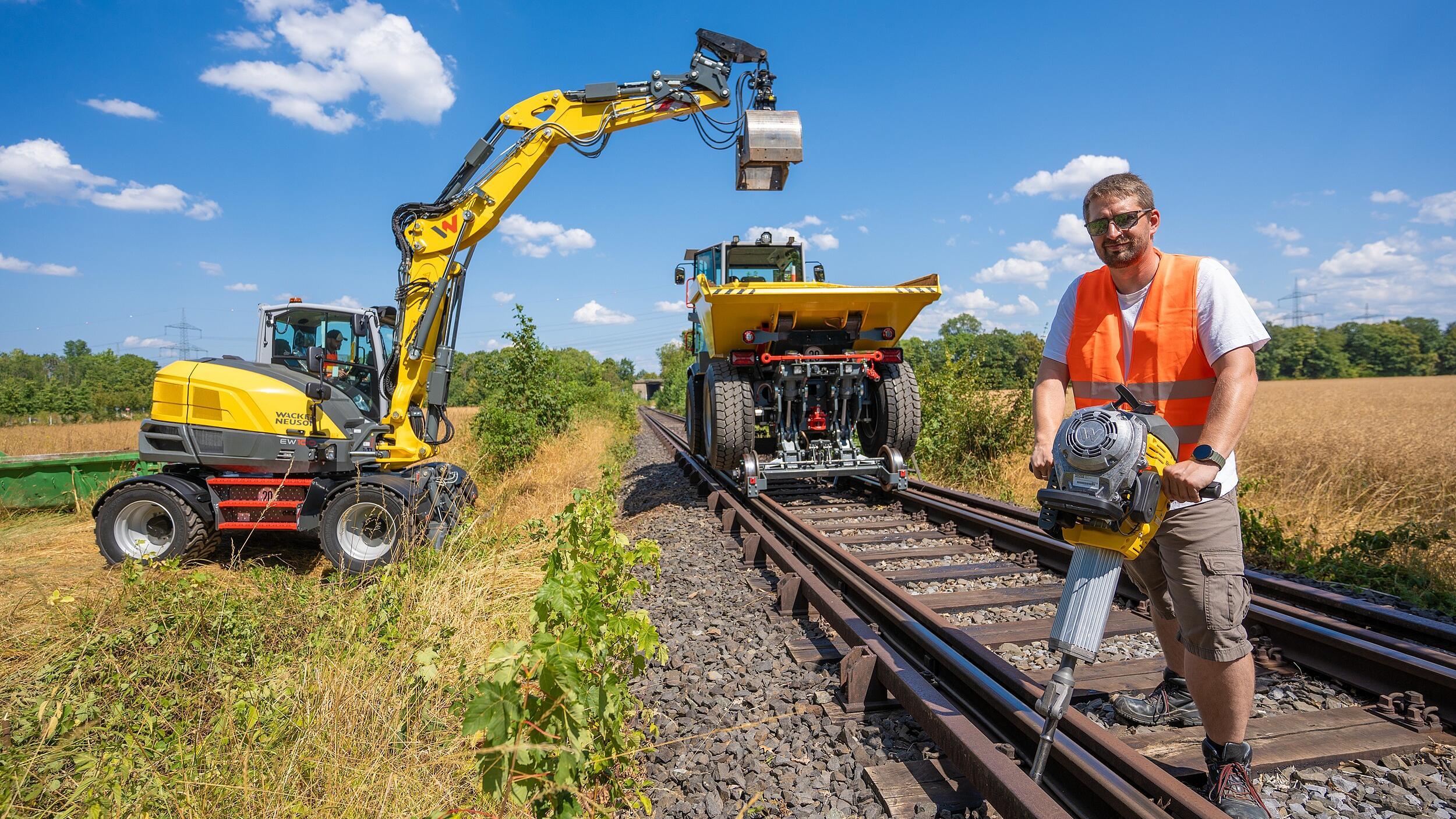 Während der Gleisstopfer BH55rw präzise Stopf- und Unterfütterungsarbeiten im Gleisbett übernimmt, sorgen der Zwei-Wege-Dumper DV90 und der Mobilbagger EW100 für den effizienten Materialtransport auf der Schiene.