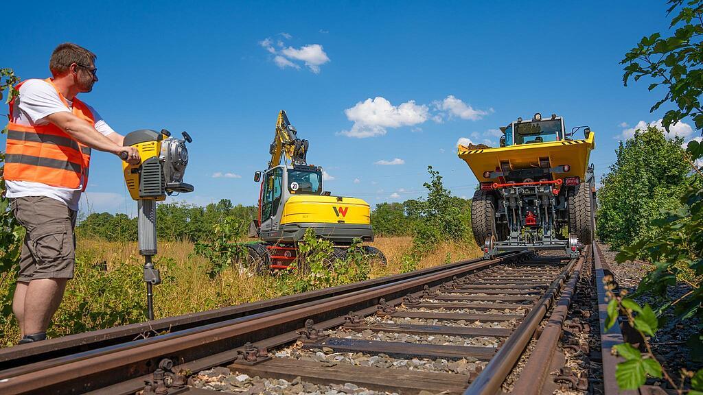 Railroad dumper, excavator and gasoline breaker at work