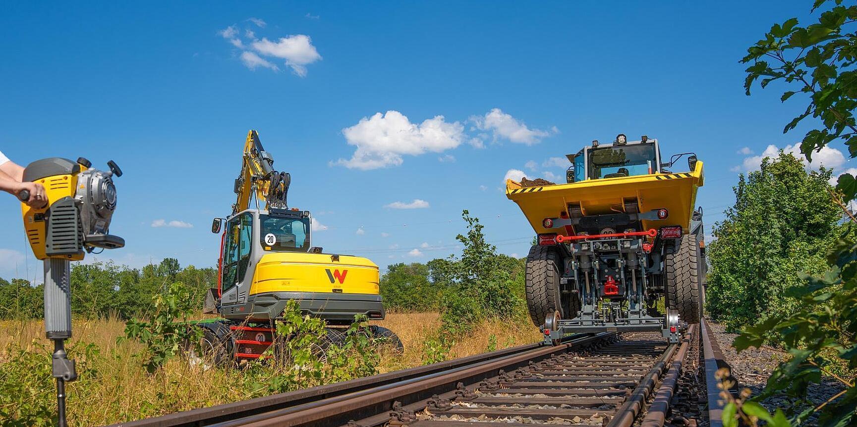 Railroad dumper, excavator and gasoline breaker at work