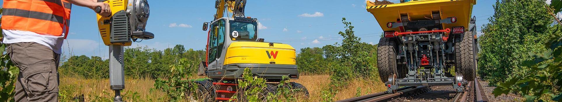 Railroad dumper, excavator and gasoline breaker at work