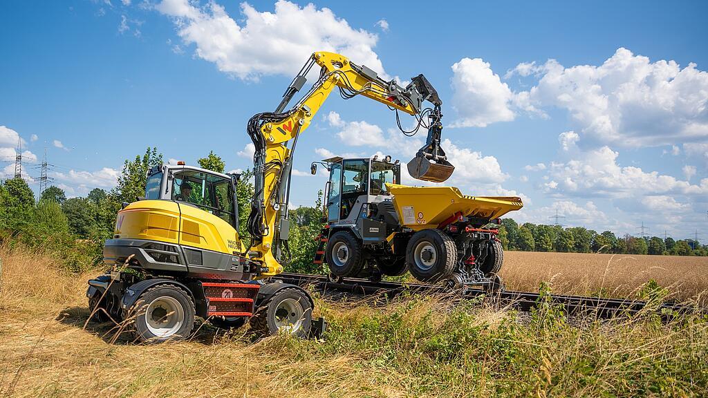 Compact Wacker Neuson dumper and hydraulic excavator operating on a rail construction site.