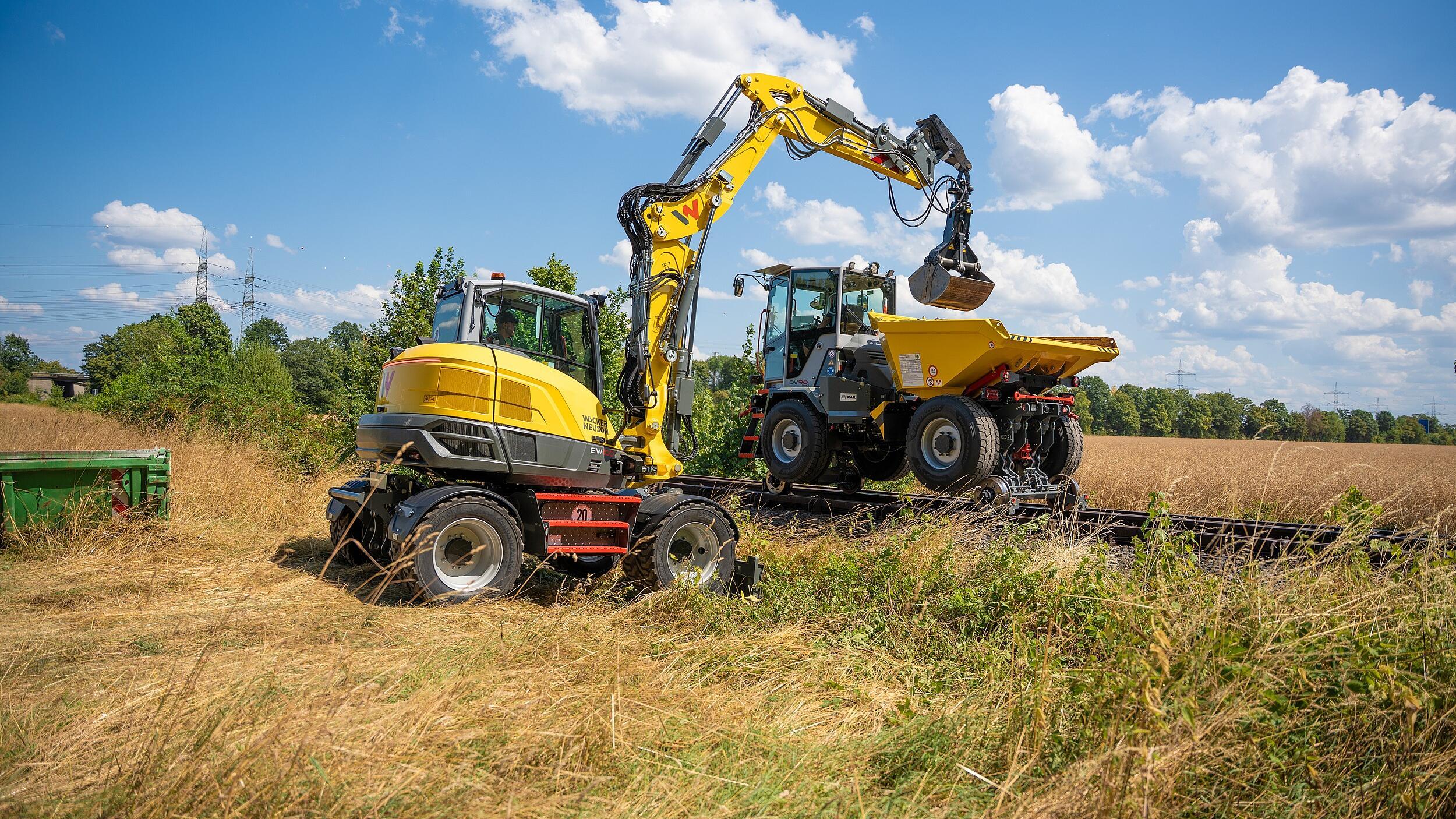 Während der Gleisstopfer BH55rw präzise Stopf- und Unterfütterungsarbeiten im Gleisbett übernimmt, sorgen der Zwei-Wege-Dumper DV90 und der Mobilbagger EW100 für den effizienten Materialtransport auf der Schiene.