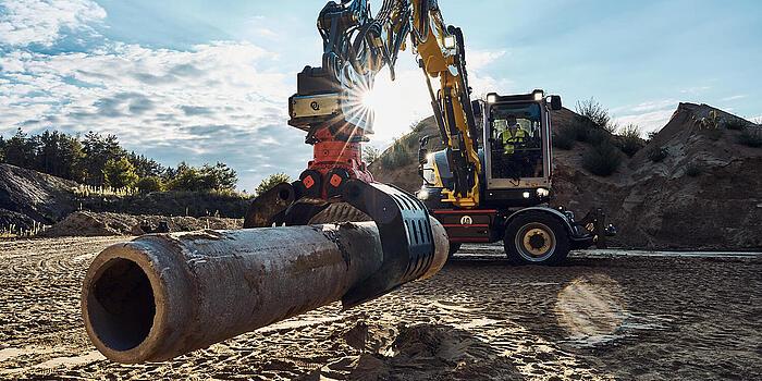 Bagger EW100 hebt Rohr 