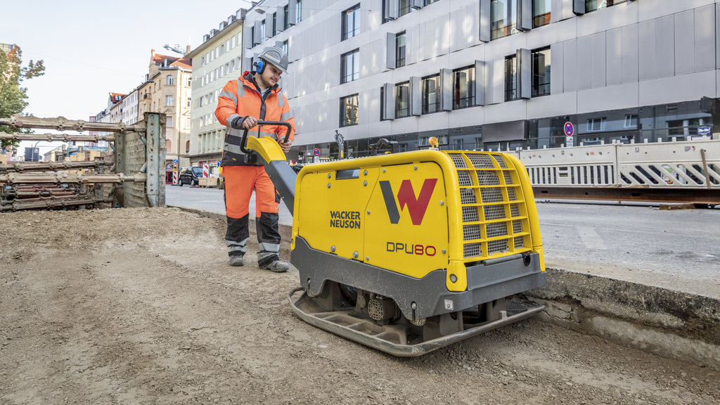 A Wacker Neuson vibratory plate in action on a construction site in the city.